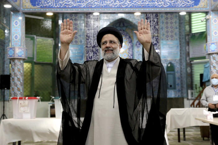 Ebrahim Raisi, a candidate in Iran's presidential elections waves to the media after casting his vote at a polling station in Tehran on Friday.