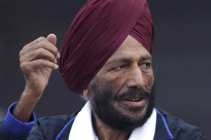 In this Dec. 15, 2013, file photo, former Indian athlete Milkha Singh, with, and Bollywood actor Bipasha Basu waves to the participants during the Delhi Half Marathon in New Delhi, India.