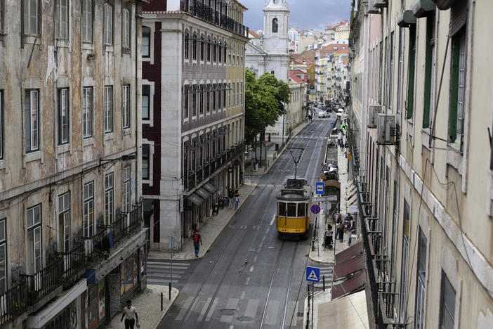A tram drives through an empty downtown Lisbon, Portugal, on Friday. Portuguese<em> </em>authorities banned all weekend travel in and out of the capital to cut down on any further spread of the coronavirus to other parts of the country.