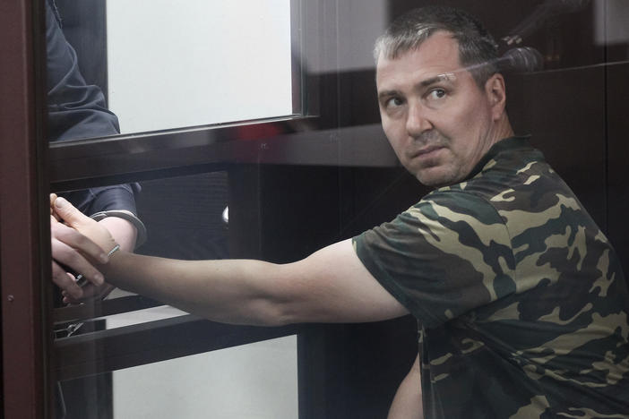 Alexander Popov, who was arrested on suspicion of murder in the death of Catherine Serou, sits behind the glass in a courtroom in the Russian city of Gorodets on June 20.