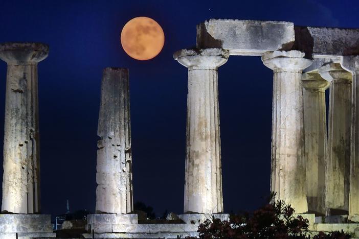 June's full moon, known as the strawberry moon, was named for its appearance during the strawberry picking season. Here, the strawberry moon rises above the Apollo Temple in ancient Corinth, on June 17, 2019.