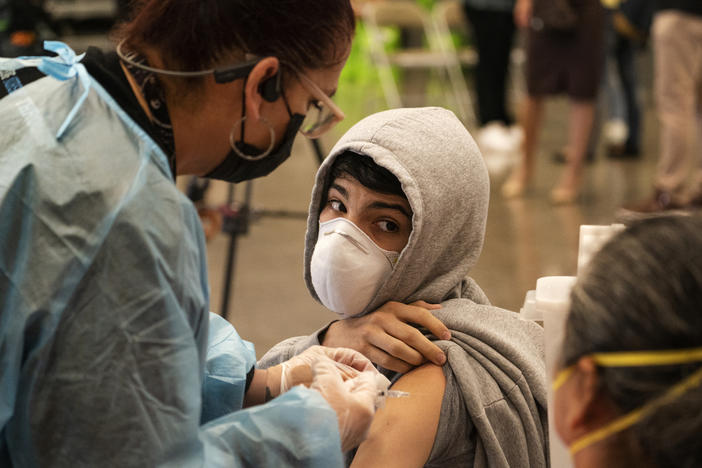 A student looks back at his mother, as he is vaccinated at a school-based COVID-19 vaccination clinic for students 12 and older in San Pedro, Calif., last month.