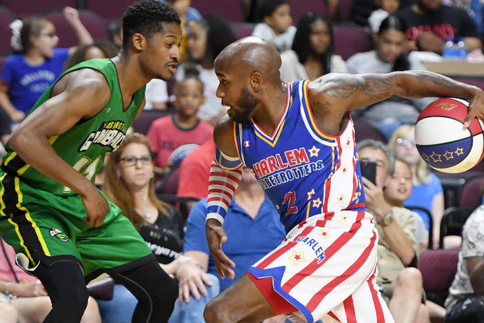 Carlos "Dizzy" English of the Harlem Globetrotters drives against Shaquille Burrell of the Washington Generals during their exhibition game at the Orleans Arena near Las Vegas.