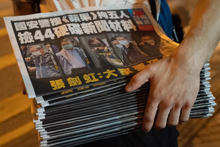A man buys multiple copies of the latest Apple Daily newspaper in Hong Kong. Police raided the office of Apple Daily, the city's fierce pro-democracy newspaper, in an operation involving more than 200 officers. Secretary for Security John Lee said the company used "news coverage as a tool" to harm national security, according to local media reports.