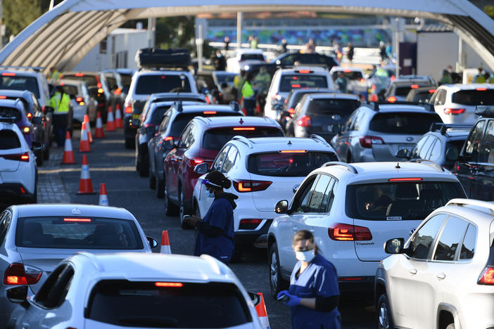 People line up in their cars to get tested for COVID-19 at a pop-up testing clinic at Bondi Beach in Sydney on Friday. Parts of Sydney will go into lockdown late Friday because of a growing coronavirus outbreak in Australia's largest city.