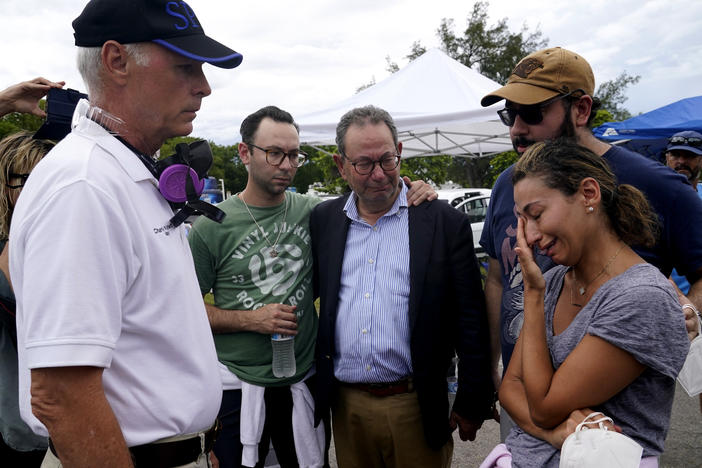 Surfside, Fla., Mayor Charles Burkett (left) talks with Rachel Spiegel, whose mother is missing in the Champlain Towers South collapse.