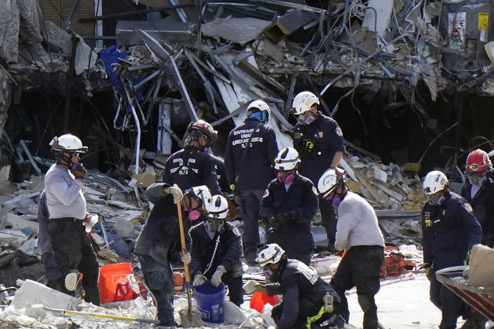 Crews work in the rubble at the Champlain Towers South condo on Sunday in Surfside, Fla. Many people are still unaccounted for after Thursday's fatal collapse.