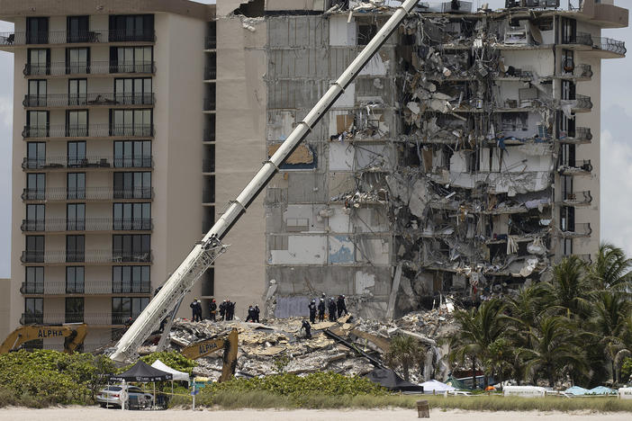 Members of the South Florida Urban Search and Rescue team look for survivors in the partially collapsed 12-story Champlain Towers South condo building in Surfside, Fla., on June 26.