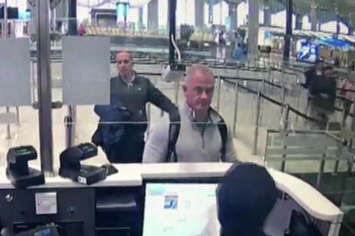 This Dec. 30, 2019 image from security camera video shows Michael L. Taylor, center, and George-Antoine Zayek at passport control at Istanbul Airport in Turkey. Taylor and his son Peter, are charged in Japan with helping Nissan's former chairman, Carlos Ghosn, jump bail and escape Japan for Lebanon.