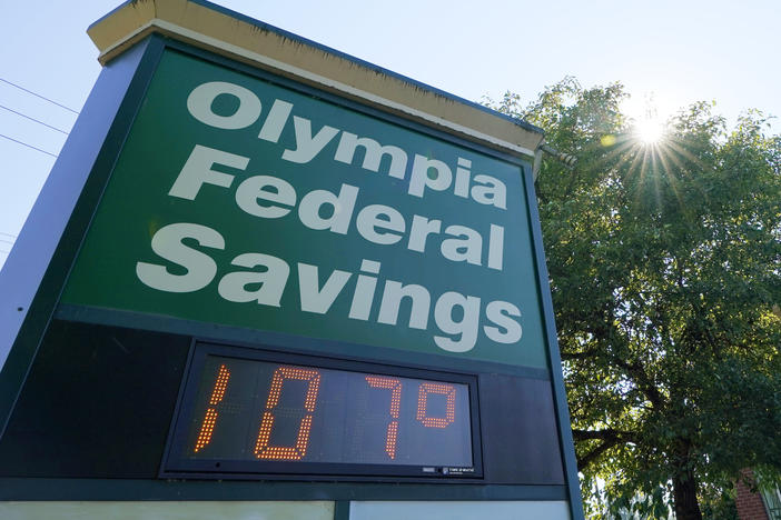 A display at an Olympia Federal Savings branch shows a temperature of 107 degrees Fahrenheit on Monday in the early evening in Olympia, Wash.