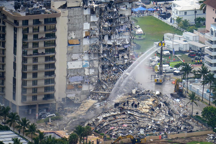 In this June 25, 2021, file photo, rescue personnel work at the remains of the Champlain Towers South condo building in Surfside, Fla.