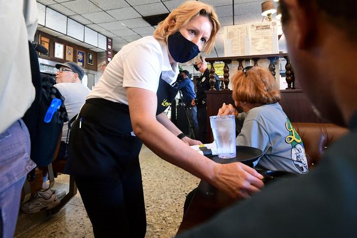 A waitress wears a face mask while serving at Langer's Delicatessen-Restaurant in Los Angeles on June 15.