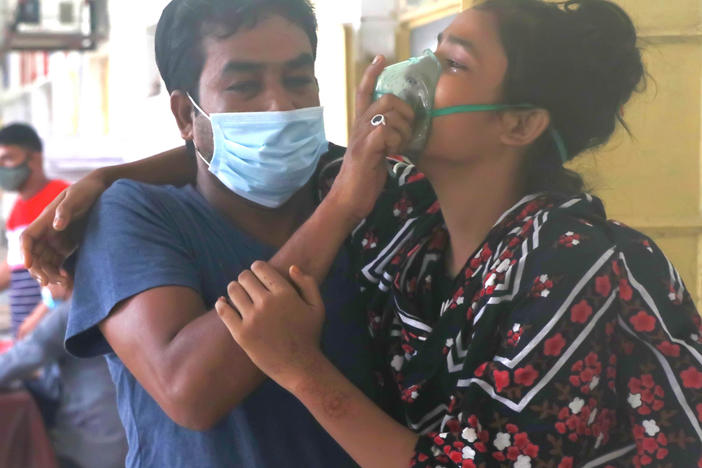 A man assists a patient with difficulty breathing at the Medical College Hospital in Rajshahi, Bangladesh, on June 16, as the delta variant of the coronavirus quickly spread.