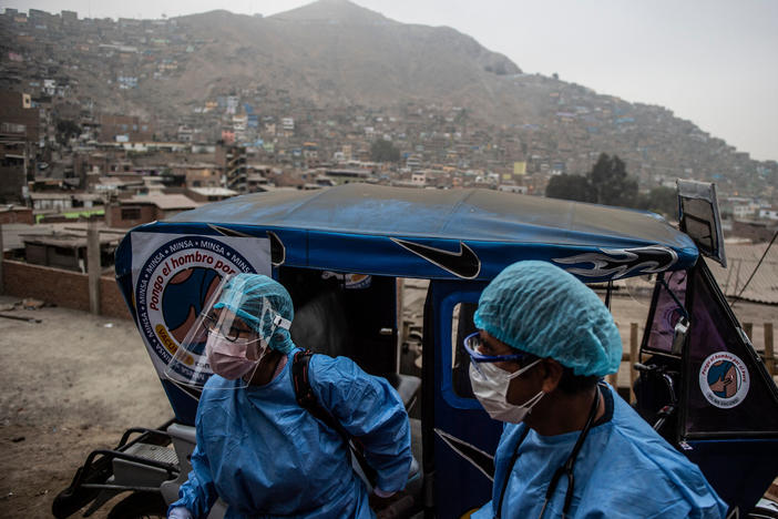 Health workers arrive in a tuk-tuk to administer doses of the Pfizer COVID-19 vaccine to elderly citizens in their homes in Lima, Peru, in April.