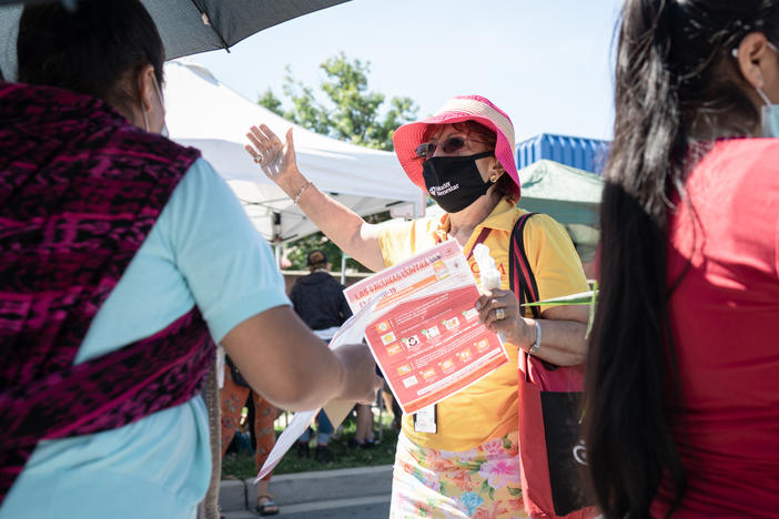 Promotora Gladis Lopez engages community members on June 23 at the Crossroads Farmers Market located at the border of Takoma Park and Langley Park, an area of suburban Maryland with a large Latino population.