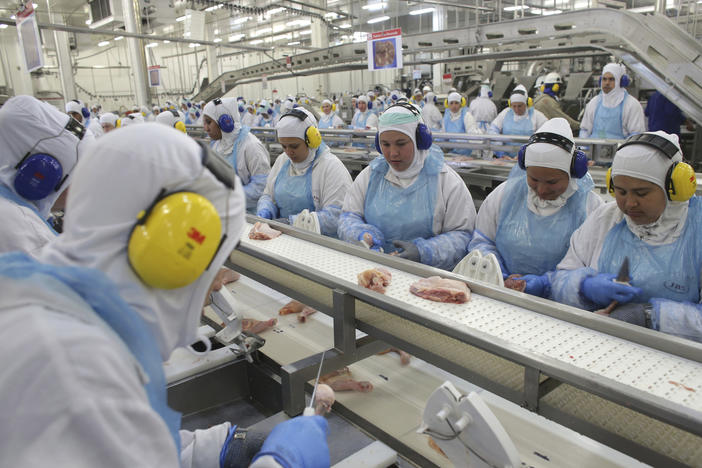 Workers prep poultry at the meatpacking company JBS in the Brazilian state of Paraná in 2017. A recent ransomware attack against JBS is raising concerns about cybersecurity at food companies.