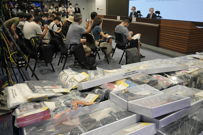 Police officials hold a news conference with confiscated evidence at police headquarters in Hong Kong on Tuesday. Police say they arrested nine people on suspicion of engaging in terrorist activity, after uncovering an attempt to make explosives and plant bombs across the city.
