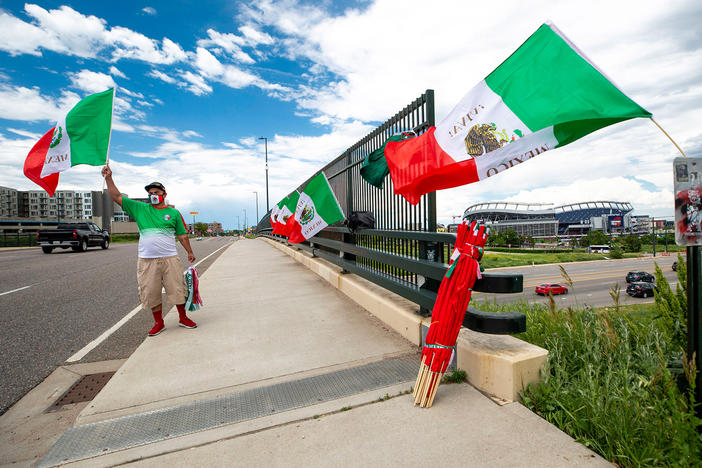 Raul Gomez sells Mexican flags Tuesday before the U.S. and Mexico national teams face off in the CONCACAF Nations League finals at Mile High Stadium.