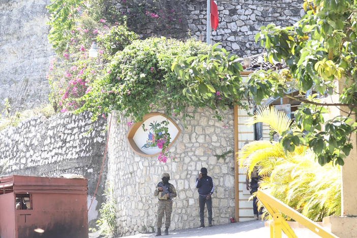 Members of the Haitian police and forensics patrol the area Wednesday as they look for evidence outside  the presidential residence in Port-au-Prince, Haiti.