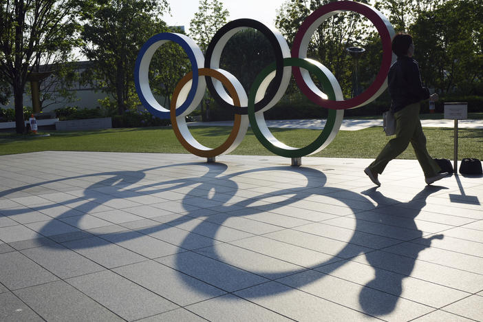 A woman passes the Olympic Rings near the National Stadium last month in Tokyo. There won't be any spectators at Olympic events in Japan's capital.