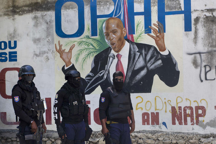 Police stand near a mural featuring Haitian President Jovenel Moïse near the leader's residence, where he was killed by gunmen in the early morning hours in Port-au-Prince, Haiti, on Wednesday.