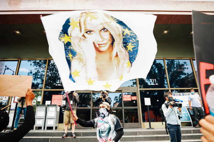 A #FreeBritney protestor flies a Britney flag outside a Los Angeles courthouse. The superstar's conservatorship case has another hearing July 14.