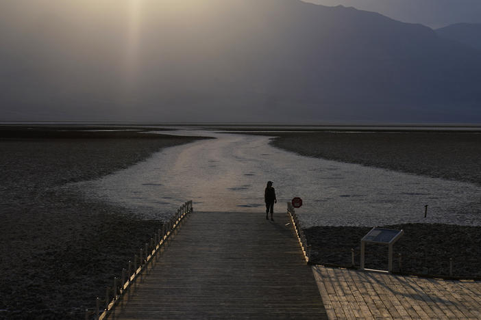 A person walks on a boardwalk at the salt flats at Badwater Basin on Aug. 17, 2020, in Death Valley National Park in California. Temperatures reached 130 degrees there on Friday.
