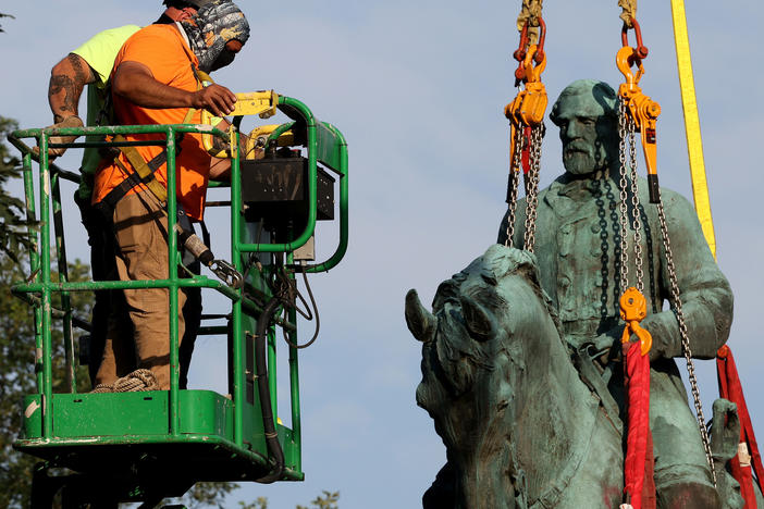 Workers remove a statue of Confederate Gen. Robert E. Lee from Market Street Park on Saturday in Charlottesville, Va.