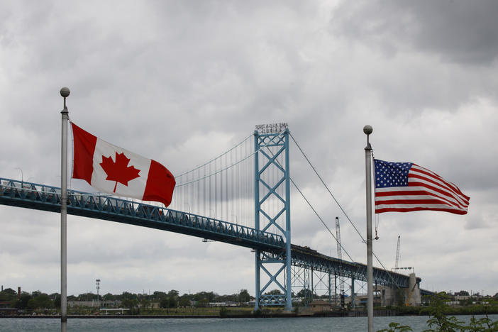 Canadian and American flags fly near the Ambassador Bridge connecting Canada to the U.S. in Windsor, Ontario, in May. Half of respondents in a poll of Canadians this month by Nanos Research said restrictions on travel across the U.S.-Canada border should not be eliminated until this fall or next year.