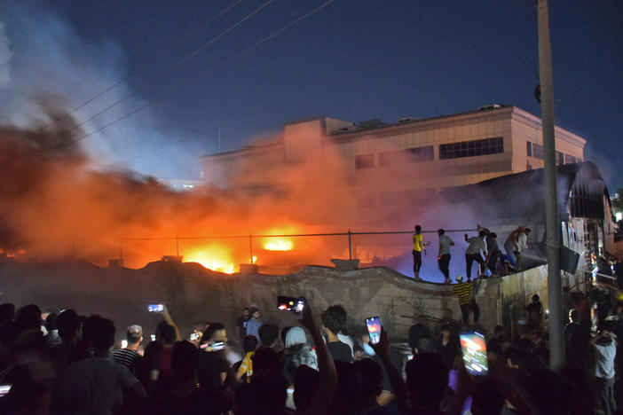 People gather as a massive fire engulfs the coronavirus isolation ward of al-Hussein hospital in the southern Iraqi city of Nasiriyah, late on Monday.