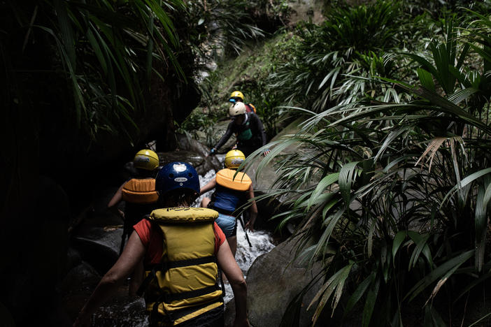 While rafting down the Guejar River, tourists stop to hike along a stream to a waterfall near the town of Mesetas, which used to be under FARC rebel control in southern Colombia.