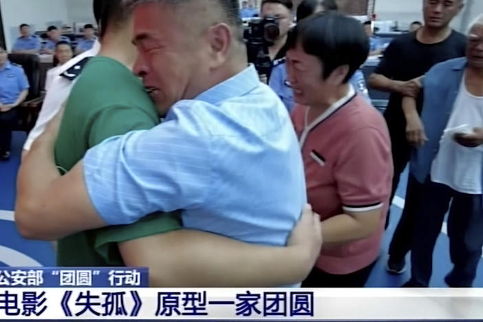 Guo Gangtang, right, embraces his son Guo Xinzhen during a reunion after 24 years in Liaocheng, in Central China's Shandong province.