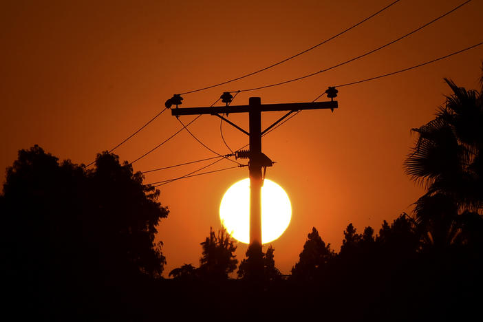 The sun sets behind power lines in Los Angeles in September.