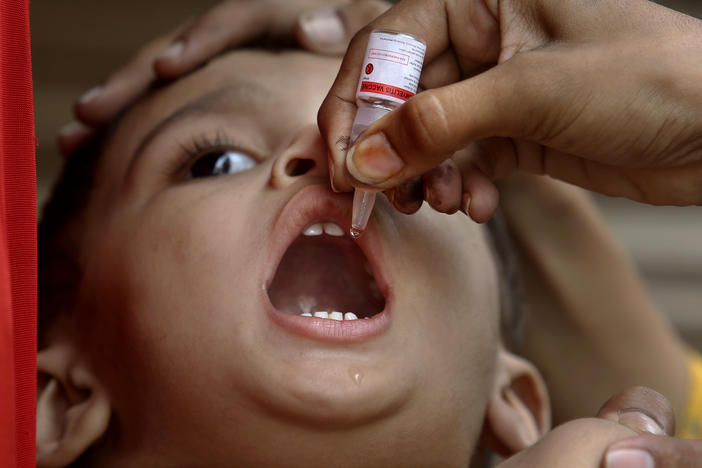 A health worker administers a polio vaccine to a child in Karachi, Pakistan, on June 9.