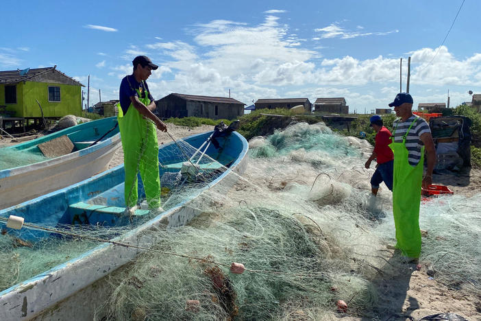 Mexican fishermen tend to their nets on Bagdad Beach, just south of the Texas-Mexico border. Red snapper poaching along the Gulf is a multi-million dollar black market.