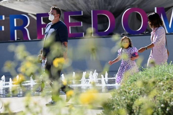 People enjoy an outdoor art exhibition in downtown Los Angeles in early July. Los Angeles County public health authorities are now urging unvaccinated and vaccinated people alike to wear face coverings in public indoor spaces because of the growing threat posed by the more contagious delta variant.