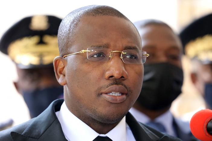 Claude Joseph speaks during a press conference Friday in Port-au-Prince. The country's interim prime minister says he's optimistic about forming a unity government.
