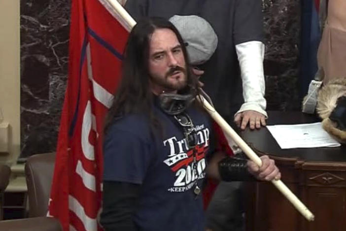 In this image from U.S. Capitol Police video, Paul Hodgkins of Tampa, Fla., stands in the well on the floor of the U.S. Senate on Jan. 6. On Monday, he was sentenced to eight months in prison.