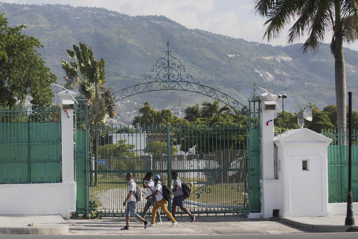 Pedestrians walk past the National Palace in Port-au-Prince, Haiti, Wednesday, July 7, 2021. A squad of gunmen assassinated Haitian President Jovenel Moise and wounded his wife in an overnight raid on their home Wednesday(AP Photo/Joseph Odelyn)