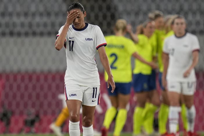 U.S. player Christen Press reacts as Sweden's players celebrate their third goal during a women's soccer match at the Olympics on Wednesday in Tokyo.