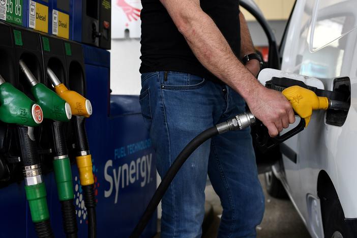 A man refuels his car in Paris in 2020. Men spend their money on greenhouse gas-emitting goods and services at a much higher rate than women, researchers found.