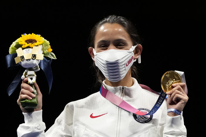 Gold medalist Lee Kiefer of the United States shows her medal and victory bouquet during the medal ceremony for the women's individual foil final competition on Sunday at the Summer Olympics.