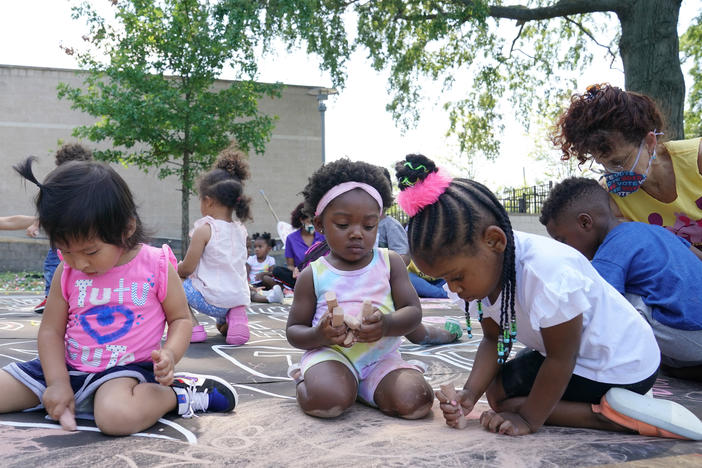 Children and teachers from the KU Kids Deanwood Child Care Center complete a mural in celebration of the launch of the child tax credit on July 14 in Washington, D.C. Tens of millions of parents have received their first monthly child tax credit payment, but it might make sense to opt out of the rest of the payments and wait until next year to claim the credit in full.