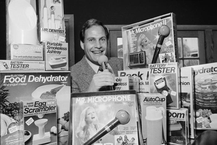 In this 1982 file photo, Ron Popeil, the man behind those late-night, rapid-fire television commercials that sell everything from the Mr. Microphone to the Pocket Fisherman to the classic Veg-a-Matic, sits surrounded by his wares in his office in Beverly Hills, Calif. Popeil died Wednesday, his family said.