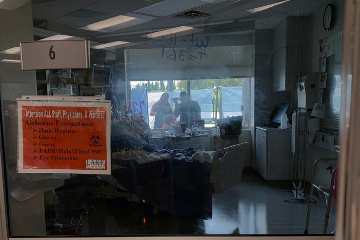 Family members gather outside the window of a COVID-19 patient at Lake Regional Hospital in Osage Beach, Mo., on Monday.