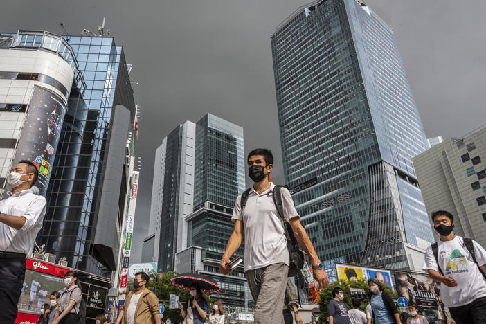 People wearing face masks cross Shibuya crossing on July 30, 2021 in Tokyo, Japan. Tokyo has seen day-on-day record increases in COVID-19 infection rates over the last three days causing concern amongst officials in Tokyo.