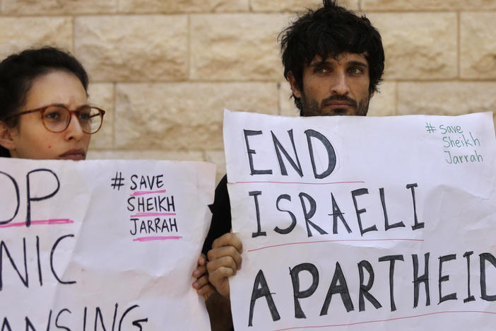 Protesters hold signs during a hearing on the possible evictions of Palestinians from the Sheikh Jarrah neighborhood of Jerusalem, outside the Israeli Supreme Court in Jerusalem on Monday, Aug. 2, 2021.
