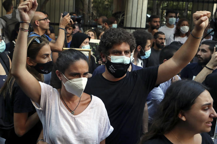 Tracy and Paul Naggear, the parents of 3-year-old Alexandra, who was killed in last year's massive blast, raise their fists during a protest outside the home of caretaker Interior Minister Mohamed Fehmi, in Beirut, July 13. A year after the deadly blast, families of the victims are seeking justice for their loved ones.