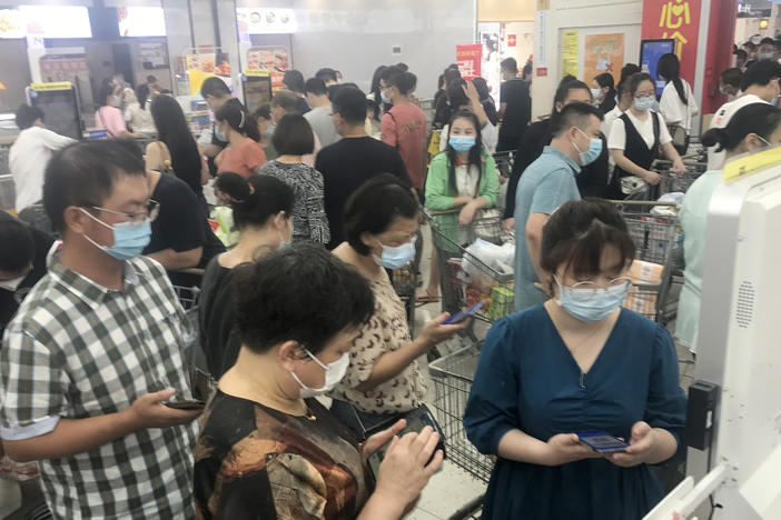 Shoppers turn out heavily Monday at a supermarket in Wuhan, China, after nearby residential blocks went into lockdown as part of COVID-19 prevention measures.