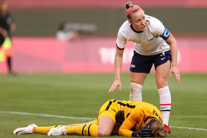 U.S. goalkeeper Alyssa Naeher lies injured as Becky Sauerbrunn checks on her during the women's semifinal match between Team USA and Canada on Monday at the Tokyo Olympic Games at Kashima Stadium.